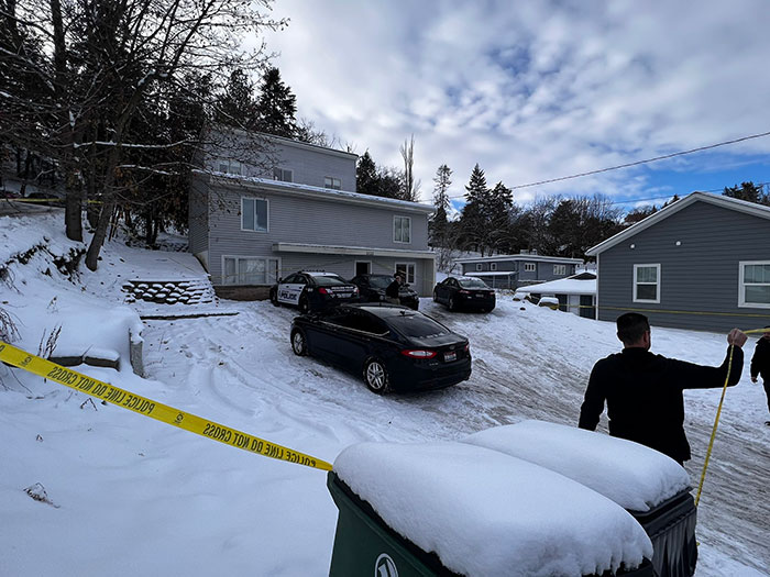 Police vehicles and officers at a snowy crime scene with yellow tape after unsealed docs reveal details about Bryan Kohberger. - 3