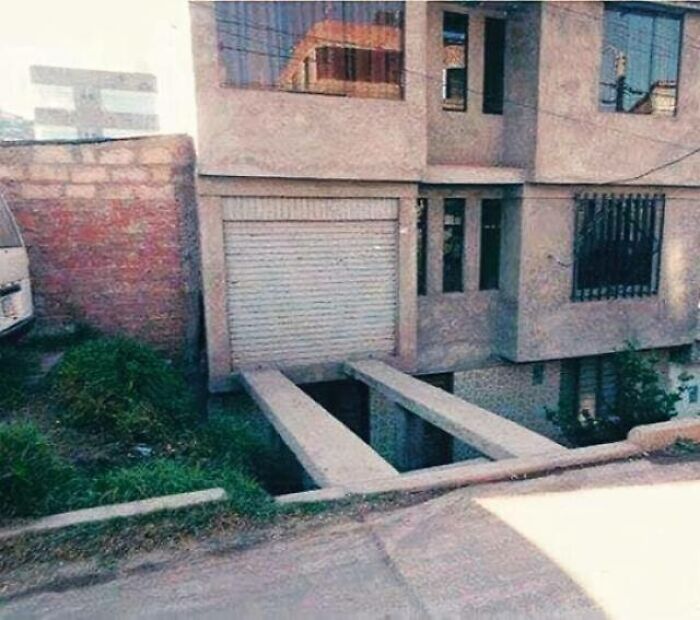 House construction with a garage door opening to nowhere and narrow concrete beams as a failed home design attempt.