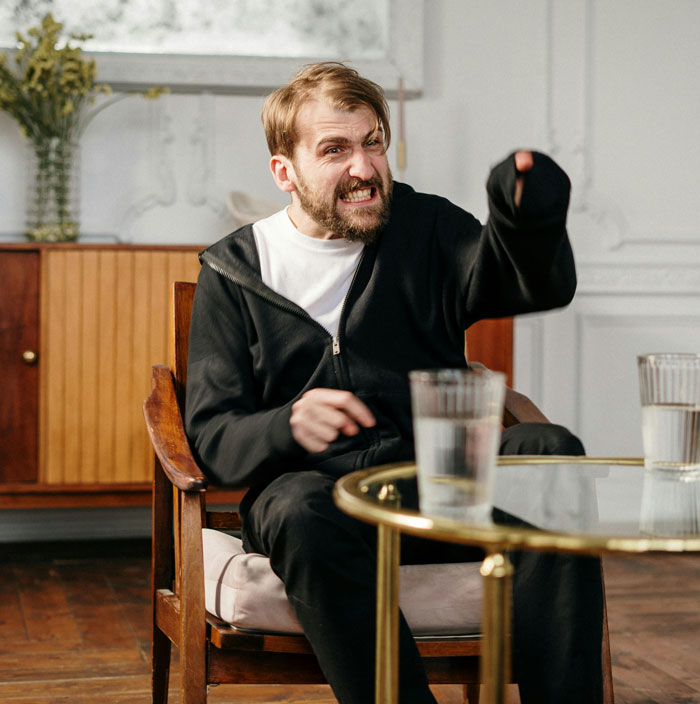 Man expressing anger during a therapy session, illustrating differences between men and women in emotional expression. - 12