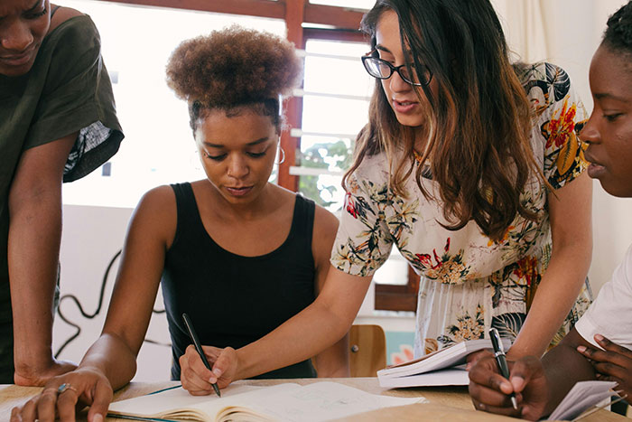 Group of women collaborating and discussing ideas, highlighting diverse perspectives on microfeminisms and social dynamics.