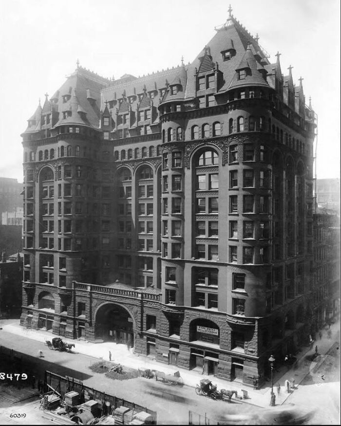 Historic old architecture of a grand building with detailed stonework and ornate rooftop design in a city setting.