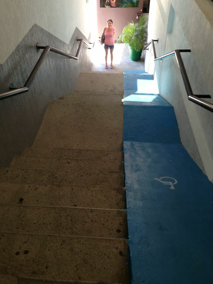 Blue painted wheelchair ramp alongside stairs in a home showing failed creative home accessibility design.