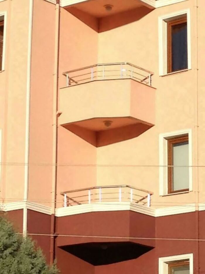 A building with two balconies stacked, one casting a shadow creating an optical illusion of a floating balcony, home design fail.