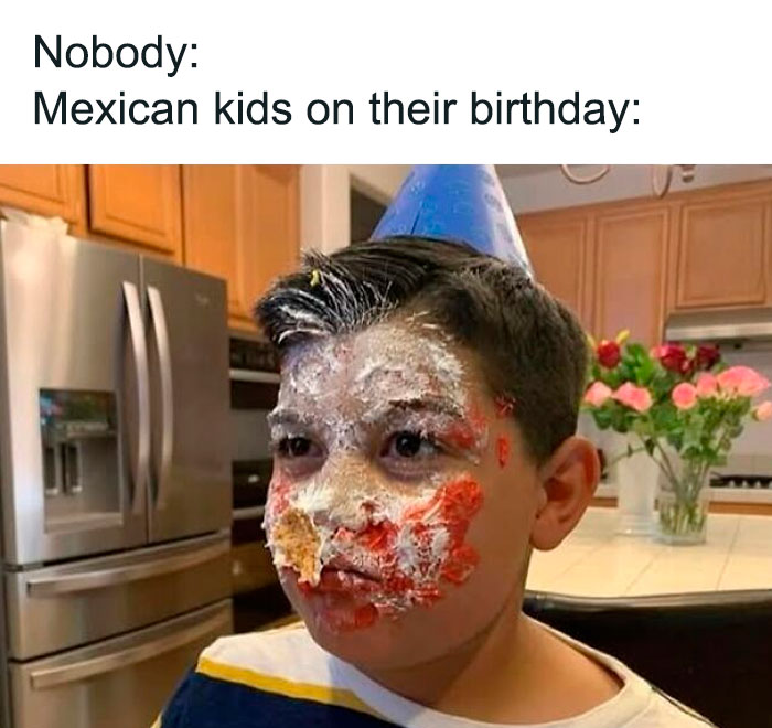 Young Hispanic boy with birthday cake smeared on his face wearing a party hat, illustrating funny Hispanic memes.