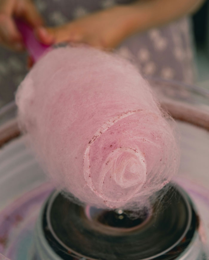 Cotton candy being spun on a stick, illustrating moments people regretted accepting a wedding invitation. - 2