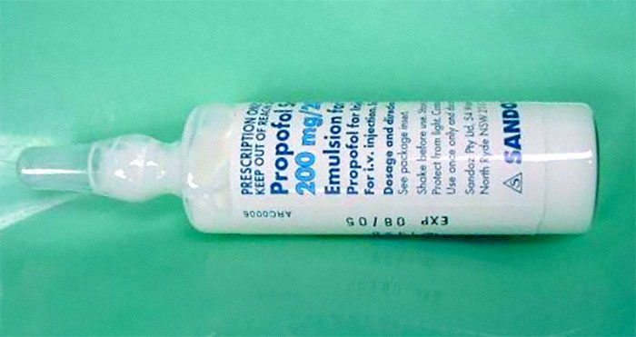 Frasco de medicamento en aerosol sobre superficie verde relacionado con errores médicos en hospitales.