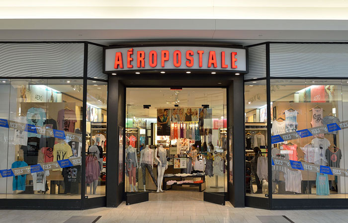 A clothing store entrance with mannequins, illustrating women sharing inappropriate comments heard in public spaces.