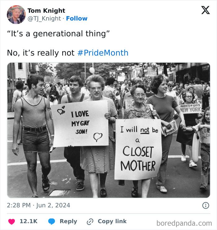 Black and white photo of people holding supportive signs at a pride march, promoting positivity and acceptance.