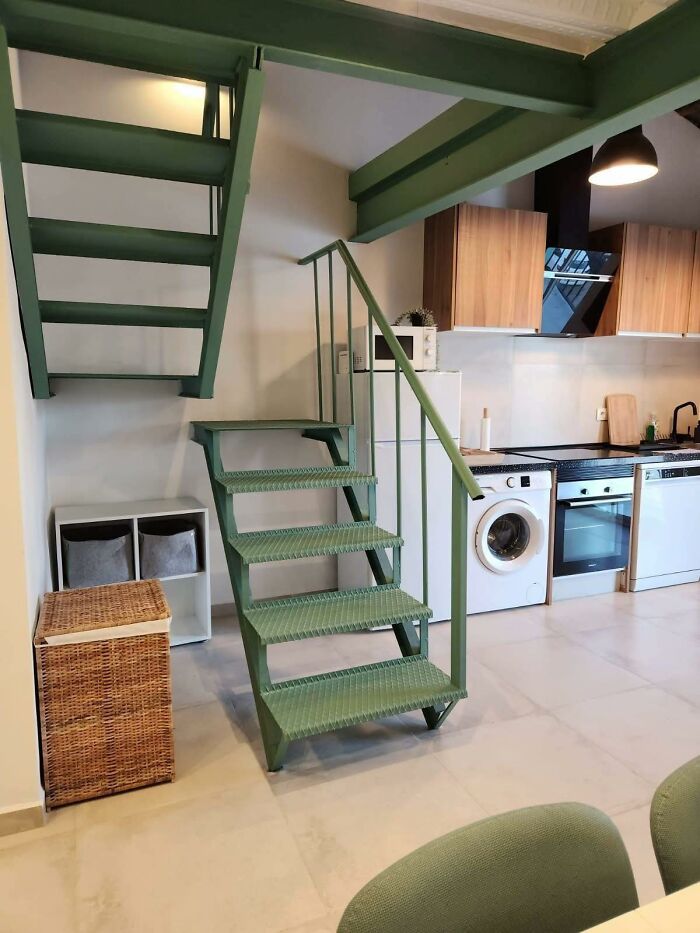 Small green metal staircase in kitchen blocking access to upper stairs, showing a creative home design fail example.