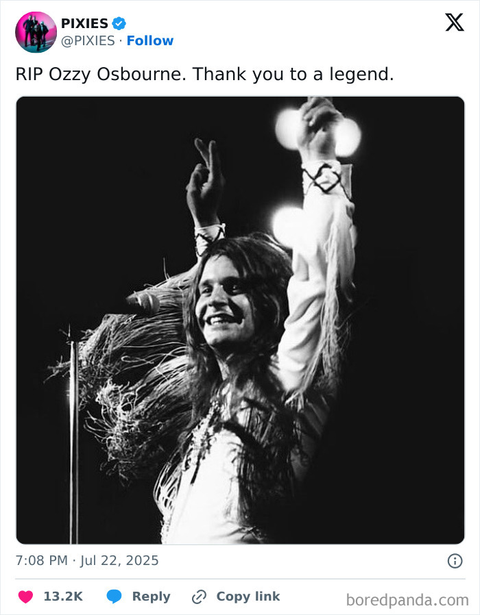 Black and white image of Ozzy Osbourne smiling on stage with arms raised, captured in a poignant tribute to rock legend.