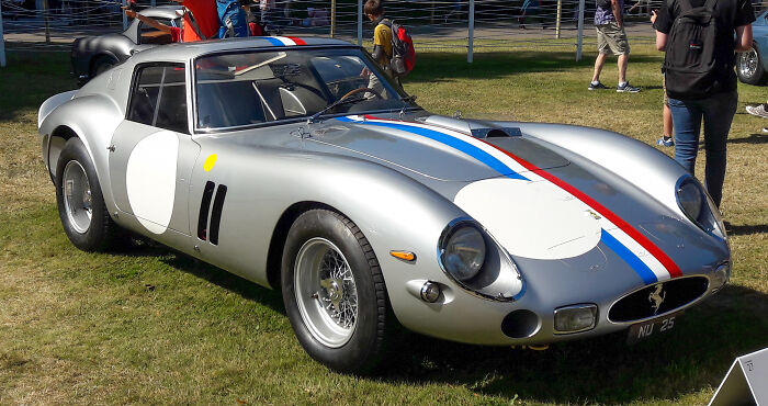 Silver classic collectible car with racing stripes displayed outdoors, representing one of the highest-value collectible items sold.