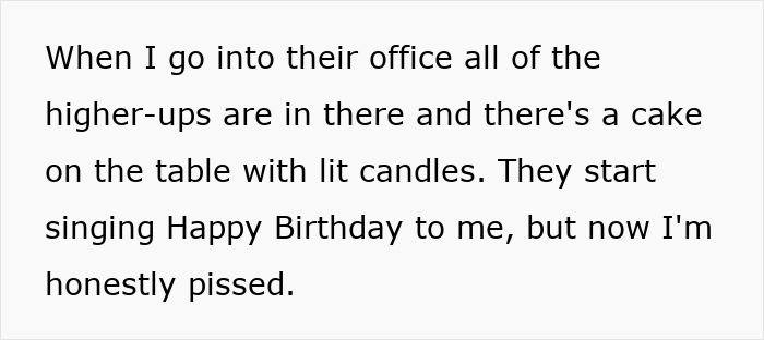 Annoyed worker standing by a birthday cake with lit candles as colleagues sing Happy Birthday in an office. - 14