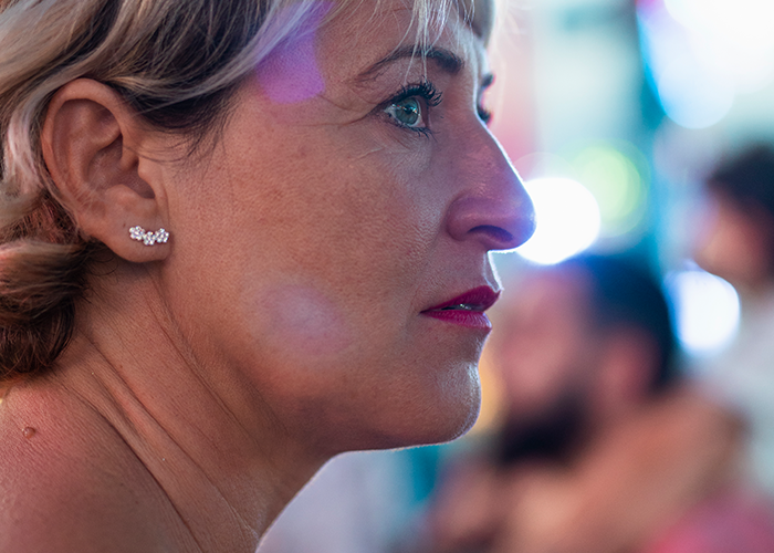 Close-up of a woman at a concert, reacting as beer is poured into her purse, annoying everyone around her. - 7