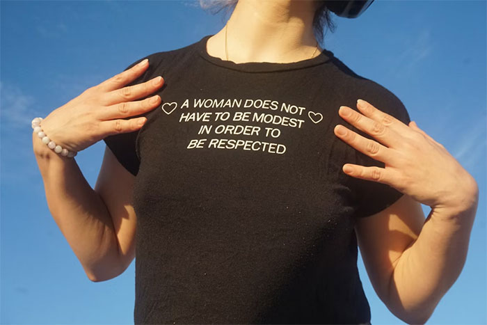 Woman wearing black shirt with message about respect, related to woman cheats on partner and childcare issues.
