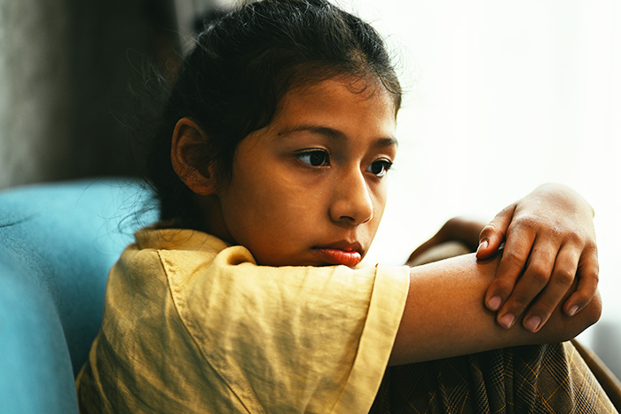 Sad young girl sitting alone, reflecting emotional stress during a difficult family and custody situation.