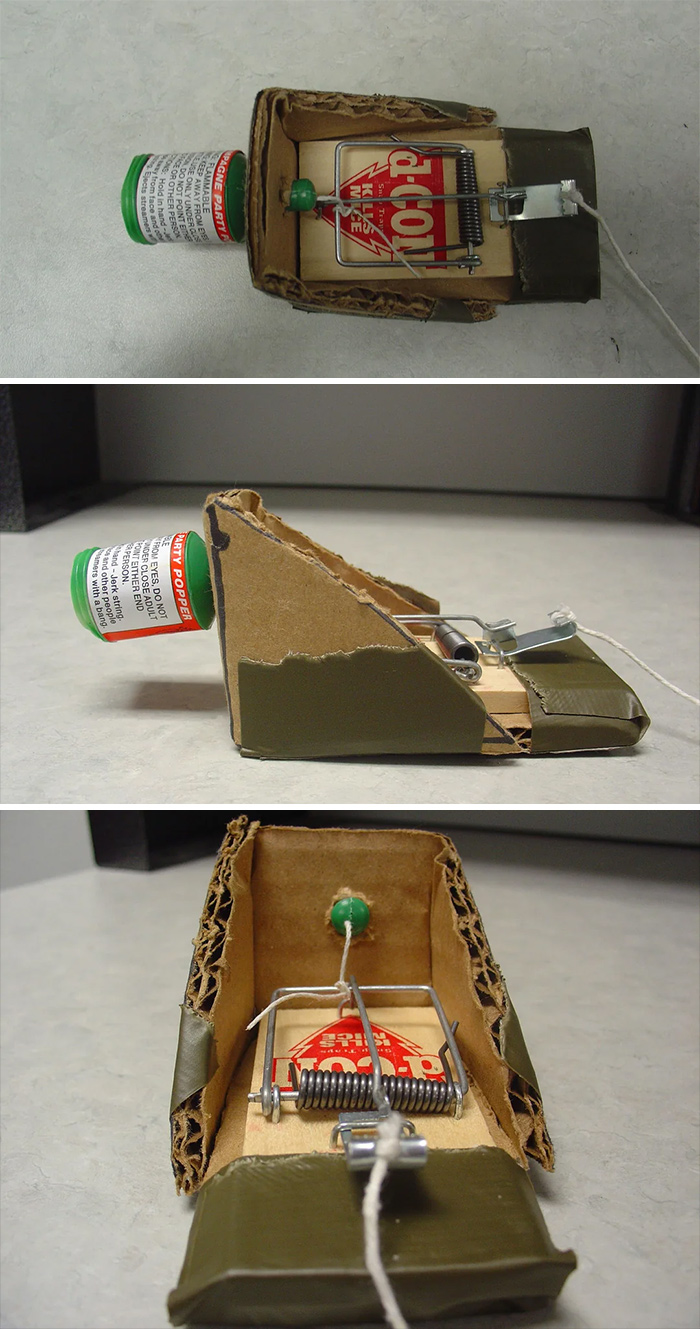 Homemade redneck engineering mousetrap modified with cardboard and a party popper for creative MacGyvering.