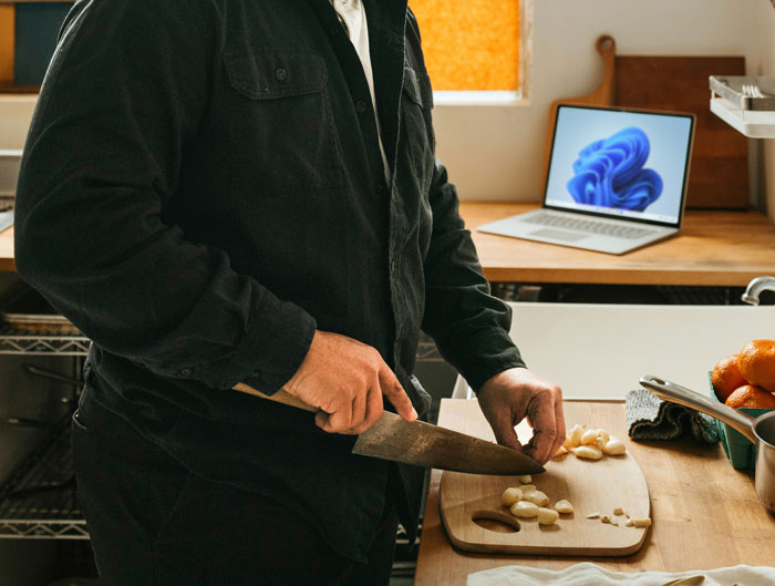Person chopping garlic on a cutting board in a kitchen, illustrating family entitlement and servant boundary issues.