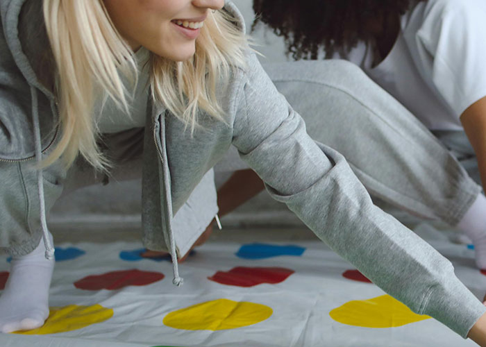 Young woman playing a game on a colorful mat, illustrating fun moments in the worst cheating stories context.