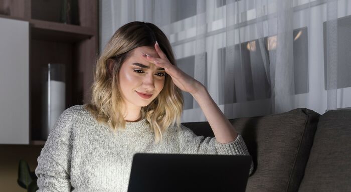 Young woman looking confused and worried while browsing laptop, illustrating normal people's habits some netizens find creepy. - 6