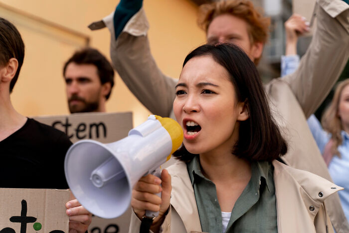 A woman using a megaphone at a protest, illustrating netizens' reactions to normal people's habits deemed creepy. - 20