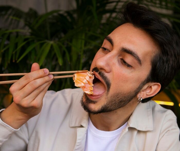 Man using chopsticks to eat raw salmon, illustrating normal people's habits some netizens find creepy in online community. - 27