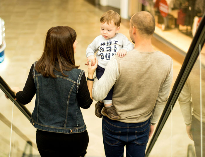 Young family with husband and wife holding their son, capturing a moment linked to husband feels sick realization about son's name. - 1