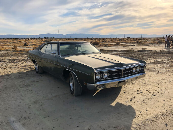Classic vintage car parked on a dry desert landscape, representing things from the good old days soon fading away.