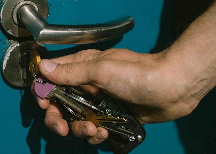 Hand holding keys unlocking a door, representing trust issues in worst cheating stories and relationship betrayals.