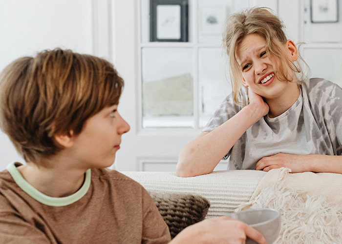 Two siblings sharing a candid moment, illustrating bizarre family habits that felt completely normal growing up.
