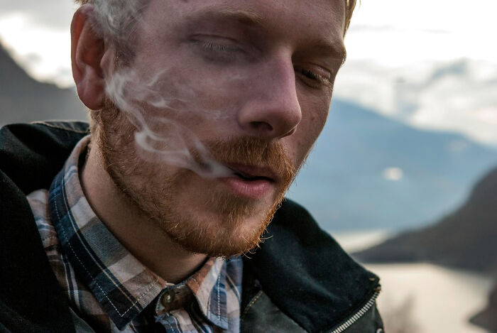 Close-up of a man smoking outdoors, illustrating one of the trends leading to overconsumption affecting lifestyle choices. - 6