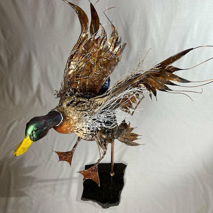 Sculpture of a flying duck made from scrap metal showcasing striking animal sculptures by an innovative artist.