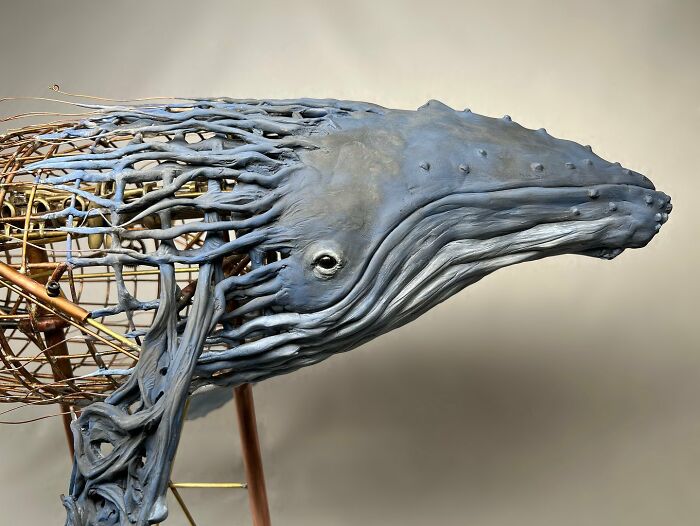 Sculpture of a whale made from scrap metal, showcasing striking animal sculptures by an innovative artist.