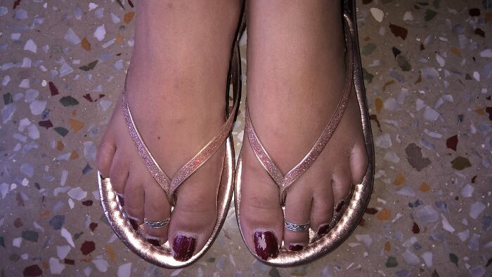 Close-up of feet wearing metallic sandals on a terrazzo floor, illustrating people who left due to partner's shenanigans.