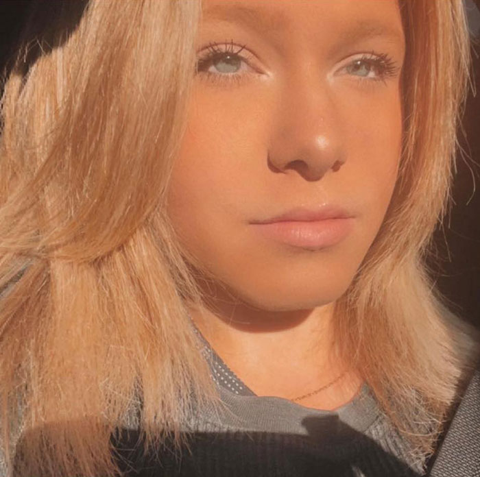 Close-up of a young girl with blonde hair and blue eyes, highlighting the story of a girl finding parents' bodies at home.