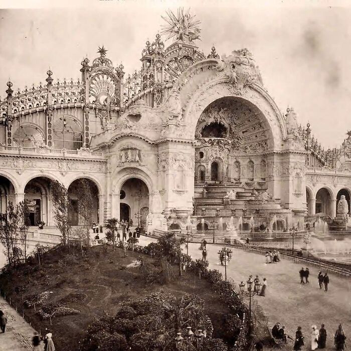 Old architecture showcasing intricate design and grand arches in a historic public building with surrounding gardens.