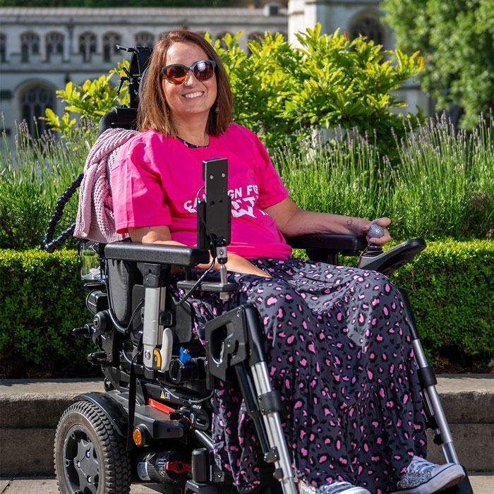 Woman in a wheelchair outdoors smiling, representing a support group after woman ended her own life by starving.