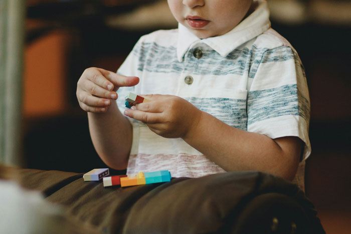 Young child playing with colorful blocks, illustrating therapists share differences between men and women concepts. - 16