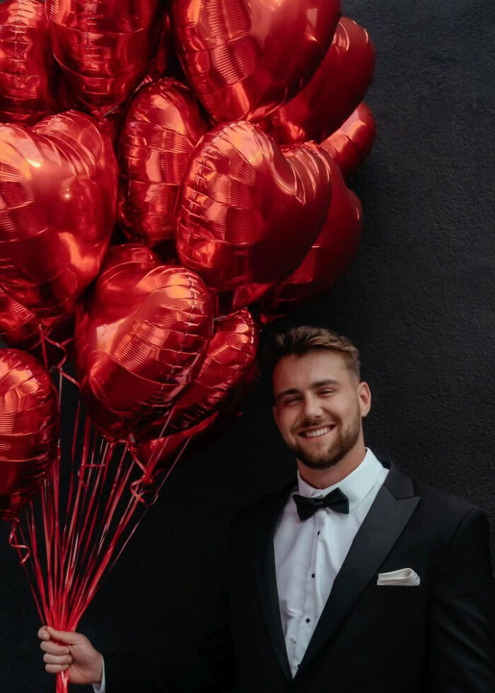 Man in tuxedo holding red heart-shaped balloons, related to Netflix email campaign targeting women to date Aussie star Man in tuxedo holding red heart-shaped balloons, related to Netflix email campaign targeting women to date Aussie star