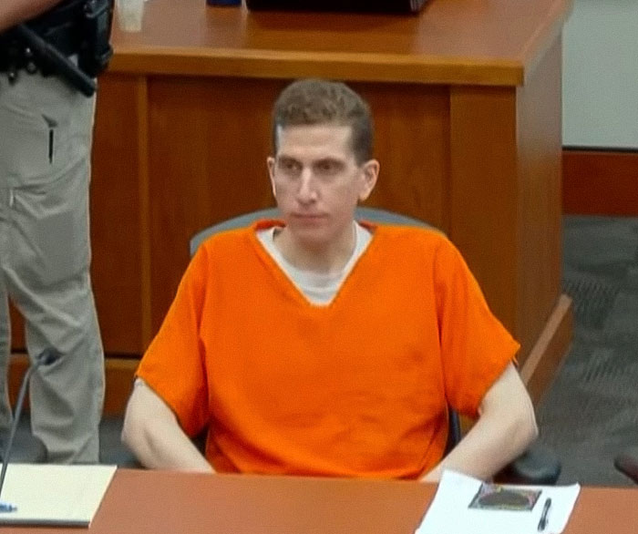Bryan Kohberger in an orange prison jumpsuit seated in a courtroom during sentencing for his crime case. - 10