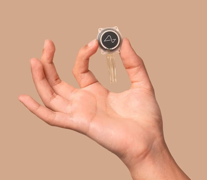 Hand holding a small Neuralink brain chip device representing Elon Musk's advanced technology for paralyzed individuals. - 5