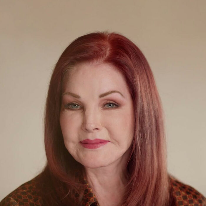 Priscilla Presley, 80, with red hair and subtle makeup, posing indoors with a calm and reflective expression. Priscilla Presley, 80, with red hair and subtle makeup, posing indoors with a calm and reflective expression.