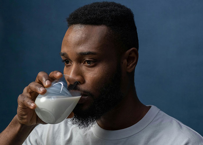 Man with beard drinking milk, representing bizarre family habits shared by people in unusual normal routines.