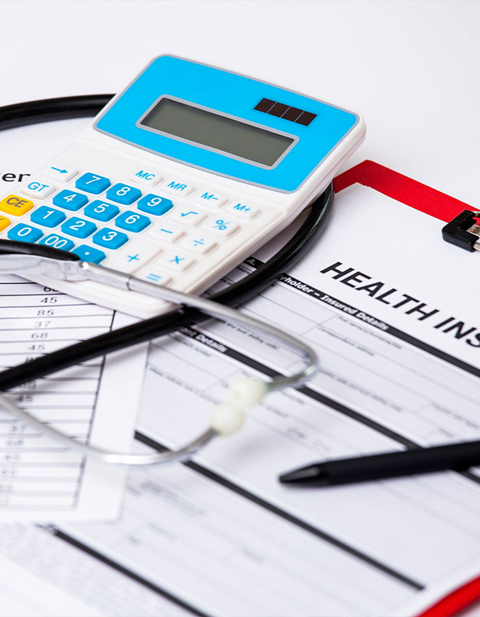 Calculator and stethoscope on health insurance forms, symbolizing financial support for an x-rated career.