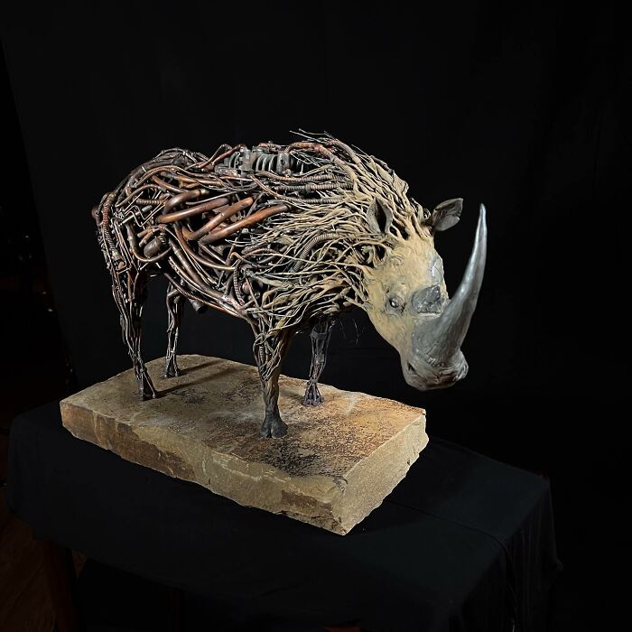 Rhino sculpture made from scrap metal pieces showcasing detailed and striking animal art by recycled materials artist.