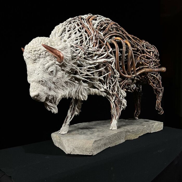 Buffalo sculpture crafted from scrap metal and wire showcasing intricate animal sculpture artistry on a stone base.