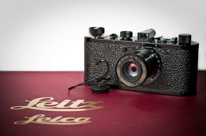 Vintage Leica camera resting on a red Leitz case, representing one of the highest-value collectible items sold.