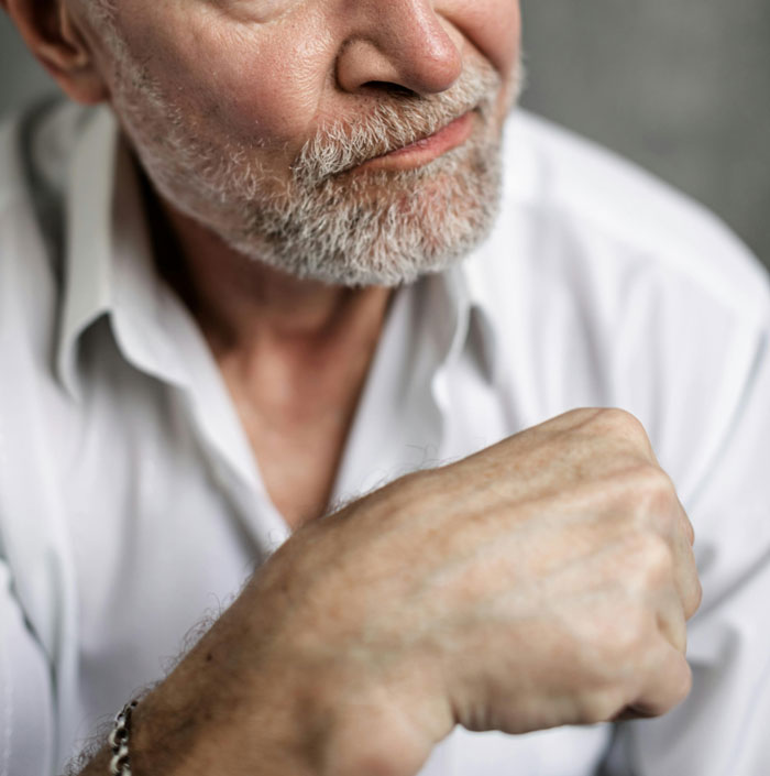 Older man with a gray beard wearing white shirt, showing frustration and waiting after message to boss following client meeting. - 4