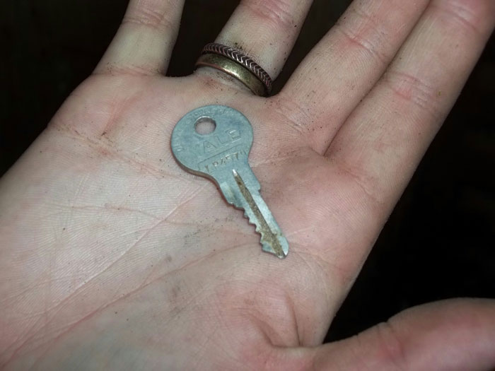 Hand holding a storage unit key left by dad, symbolizing discovery and changing perceptions forever.