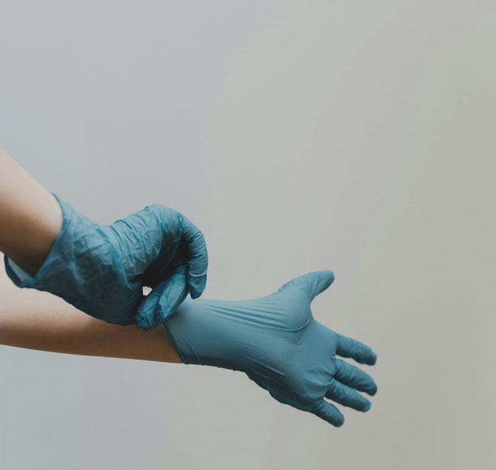 Medical professional putting on blue gloves illustrating hospital mistakes and safety risks in clinical settings.