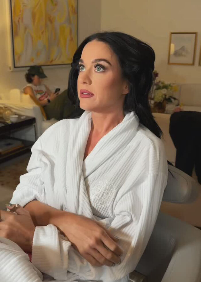 Katy Perry in a white robe, seated indoors with a thoughtful expression, amid romance rumors with Justin Trudeau. Katy Perry in a white robe, seated indoors with a thoughtful expression, amid romance rumors with Justin Trudeau.